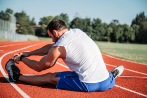 Athlete stretching on track.